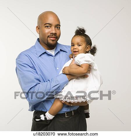 African American man holding infant girl standing against white background. View Large Photo Image Stock Image - African American man holding infant girl standing against white background.. Fotosearch