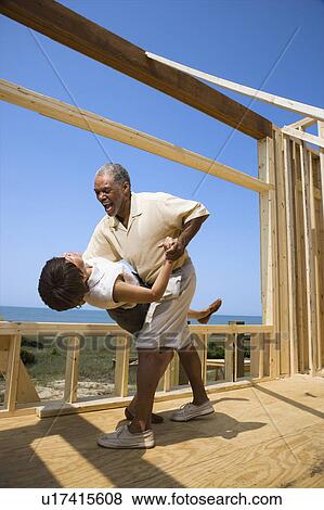 African American middle aged couple dancing in new home construction at beach. View Large Photo Image Stock Photo - African American middle aged couple dancing in new home construction at beach.. Fotosearch