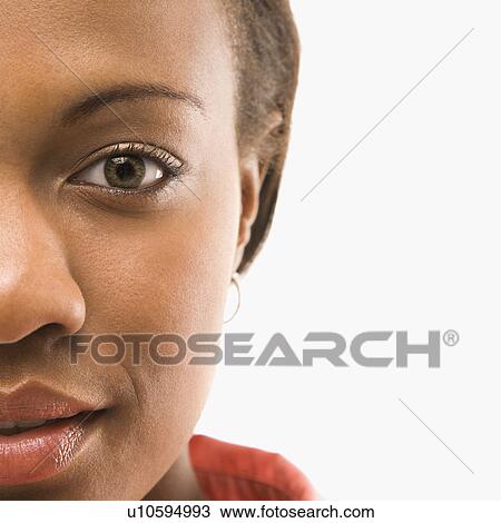 Stock Image - Close up portrait of African American woman against white background.. Fotosearch