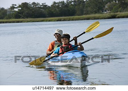 Couple smiling and paddling kayak View Large Photo Image Stock Photo - Couple smiling and paddling kayak. Fotosearch