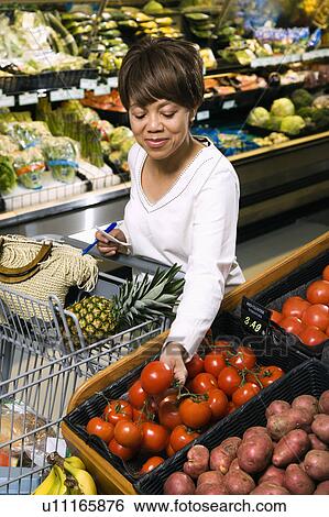 Middle aged African American woman selecting tomatoes from grocery store produce. View Large Photo Image Stock Photograph - Middle aged African American woman selecting tomatoes from grocery store produce.. Fotosearch