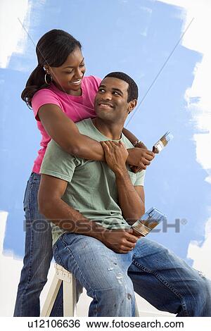 Portrait of male and female couple next to half-painted wall View Large Photo Image Stock Photograph - Portrait of male and female couple next to half-painted wall. Fotosearch