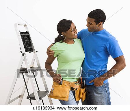 Picture - Smiling couple preparing to do home repairs. Fotosearch
