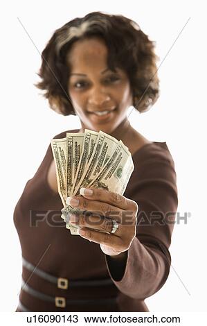 Stock Image - Woman holding twenty dollar bills in hand. Fotosearch
