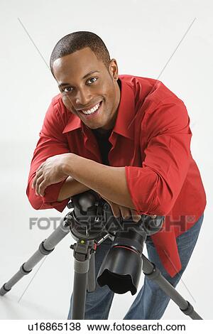 Young African American male adult photographer posing in studio. View Large Photo Image Stock Photo - Young African American male adult photographer posing in studio.. Fotosearch