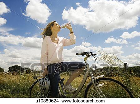 Female cyclist drinking water View Large Photo Image Picture - Female cyclist drinking water. Fotosearch