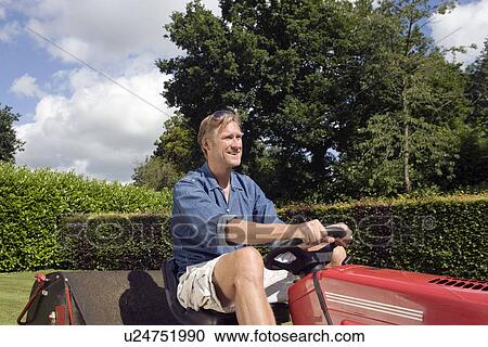 Stock Image - Man mowing a lawn. Fotosearch