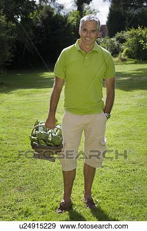 Stock Photo - Portrait of man with vegetable basket. Fotosearch