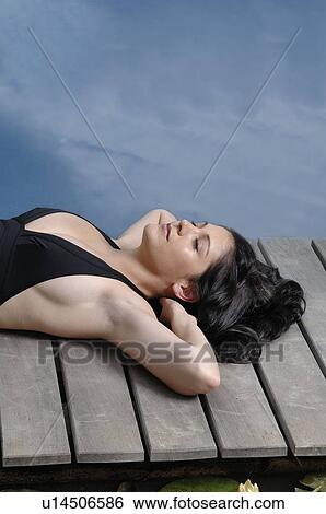 Woman lying down on wooden deck View Large Photo Image Stock Photograph - Woman lying down on wooden deck. Fotosearch