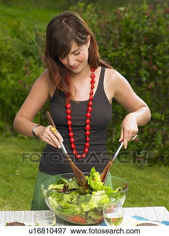 Young woman tossing a salad View Large Photo Image Stock Photo - Young woman tossing a salad. Fotosearch