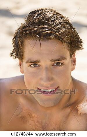 Picture - Head and shoulder portrait of handsome man on beach.. Fotosearch