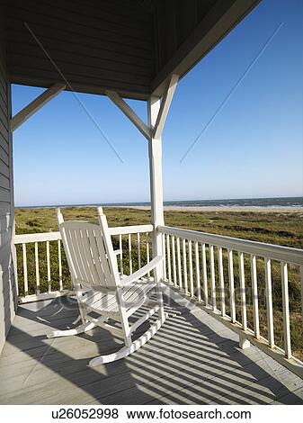 Rocking chair on porch with railing overlooking beach at Bald Head Island, North Carolina. View Large Photo Image Stock Photo - Rocking chair on porch with railing overlooking beach at Bald Head Island, North Carolina.. Fotosearch