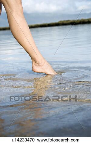 Woman dipping her toe in the water to test temperature View Large Photo Image Stock Image - Woman dipping her toe in the water to test temperature. Fotosearch