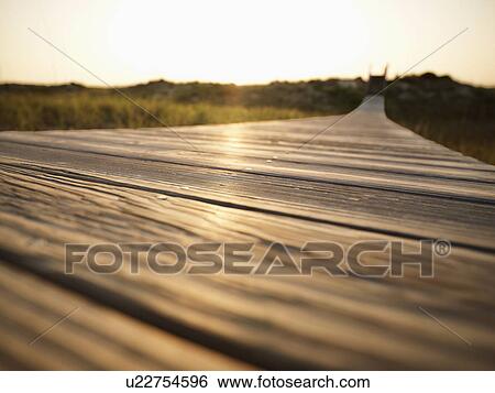 Stock Photograph - Wooden boardwalk leading to beach at Bald Head Island, North Carolina. Fotosearch