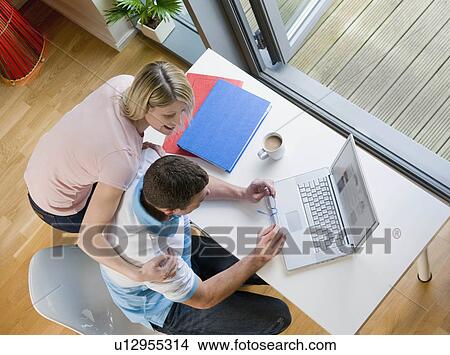 A couple looking at a laptop View Large Photo Image Picture - A couple looking at a laptop. Fotosearch