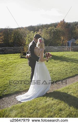 A wedding couple walking along a path View Large Photo Image Stock Photo - A wedding couple walking along a path. Fotosearch