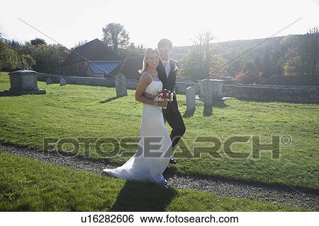 A wedding couple walking along a path View Large Photo Image Stock Photograph - A wedding couple walking along a path. Fotosearch