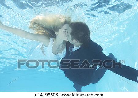 Stock Photograph - Bride and groom kissing underwater. Fotosearch