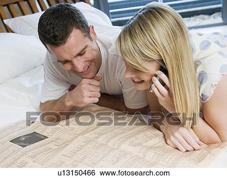Couple check stocks and shares in bed View Large Photo Image Stock Photograph - Couple check stocks and shares in bed. Fotosearch