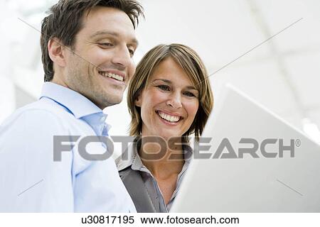 Stock Photography - Couple looking at computer display. Fotosearch