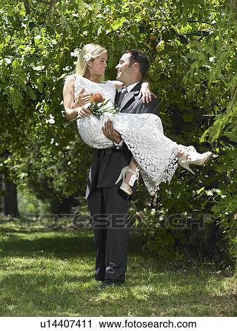 Groom carrying bride View Large Photo Image Stock Image - Groom carrying bride. Fotosearch