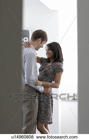 Stock Photo - Man and woman cuddling in office. Fotosearch