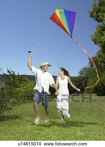 Picture - Man and woman flying kite. Fotosearch