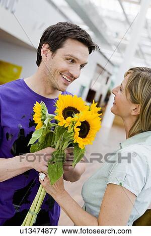 Man giving flowers to a woman View Large Photo Image Stock Photo - Man giving flowers to a woman. Fotosearch