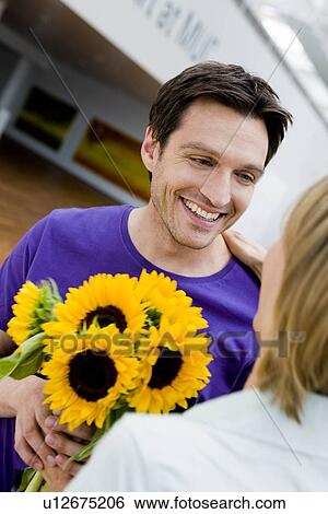 Man giving flowers to a woman View Large Photo Image Stock Photograph - Man giving flowers to a woman. Fotosearch