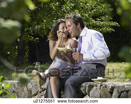 Stock Image - Wedding guests eating cake. Fotosearch