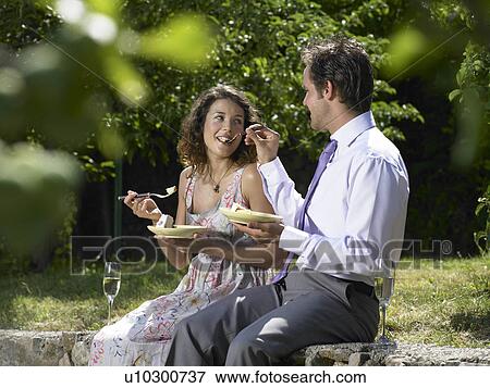 Wedding guests feeding each other cake View Large Photo Image Stock Photo - Wedding guests feeding each other cake. Fotosearch