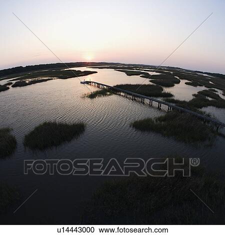 Stock Image - Aerial view of pier in coastal wetland on Bald Head Island, North Carolina.. Fotosearch