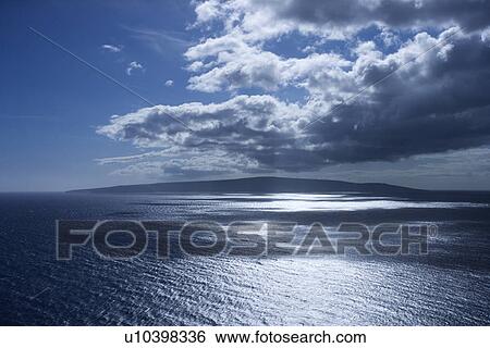 Stock Photograph - Island in Pacific ocean with puffy clouds.. Fotosearch