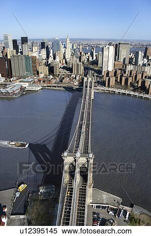 Stock Photography - Aerial view of Brooklyn Bridge with East River and Manhattan buildings in New York City.. Fotosearch