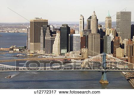 Stock Photo - Aerial view of New York City's Manhattan Bridge with Brooklyn Bridge and Manhattan buildings in background.. Fotosearch