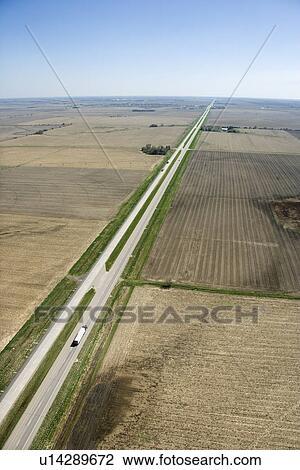 Stock Image - Aerial view of highway through rural farmland with crops.. Fotosearch