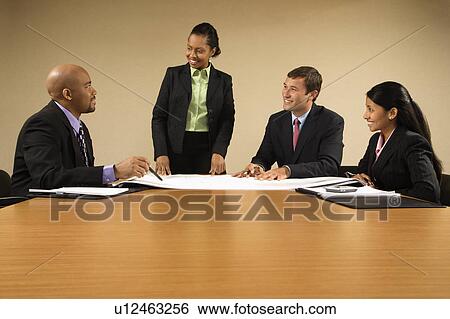 Businesspeople having meeting at conference table View Large Photo Image Stock Photograph - Businesspeople having meeting at conference table. Fotosearch