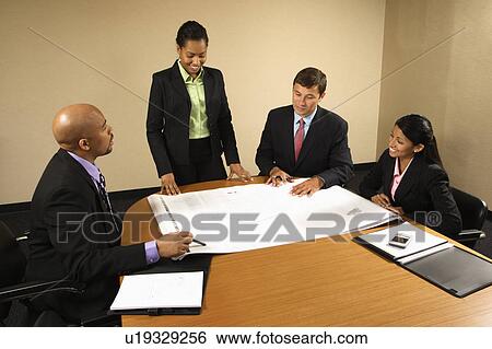 Stock Photograph - Businesspeople having meeting at conference table. Fotosearch