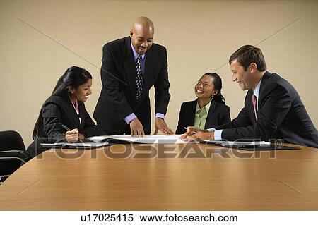 Stock Photography - Businesspeople having meeting at conference table. Fotosearch