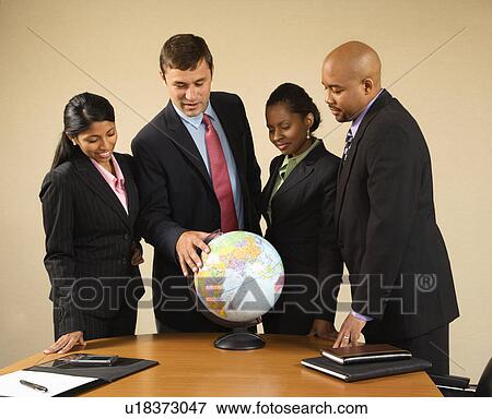 Stock Photo - Corporate businesspeople standing around world globe smiling and talking.. Fotosearch