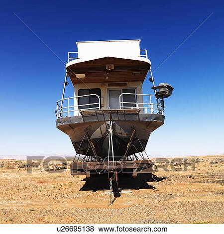 Stock Photo - Landscape of houseboat sitting in the middle of the desert. Fotosearch