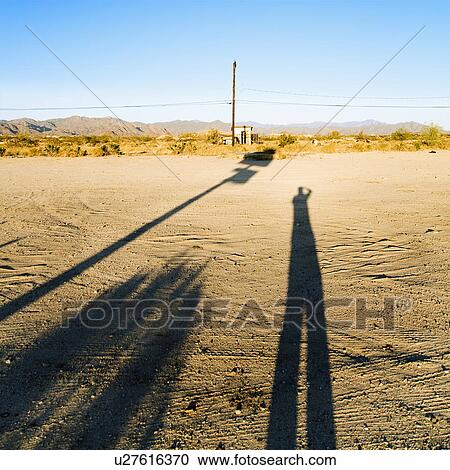 Landscape with long shadow of man and desert in the background. View Large Photo Image Stock Image - Landscape with long shadow of man and desert in the background.. Fotosearch