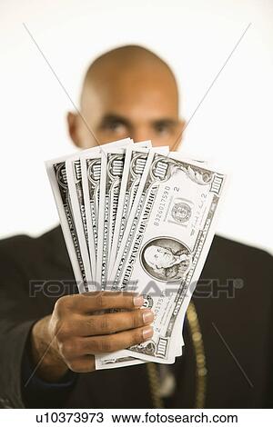 Stock Image - African American man in suit holding cash.. Fotosearch