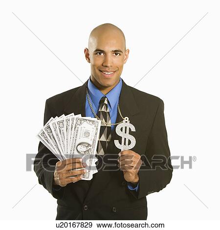 Stock Photo - African American man in suit wearing necklace with money sign and holding cash.. Fotosearch