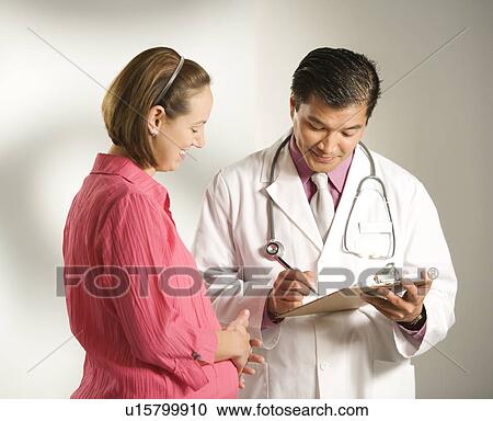 Asian American male doctor consulting with pregnant Caucasian woman. View Large Photo Image Stock Image - Asian American male doctor consulting with pregnant Caucasian woman.. Fotosearch