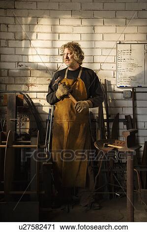 Stock Image - Caucasian male metalsmith portrait.. Fotosearch
