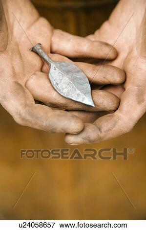 Dirty male metal smith's hands holding metal leaf View Large Photo Image Stock Photo - Dirty male metal smith's hands holding metal leaf. Fotosearch