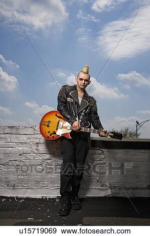 Stock Photo - Portrait of mid-adult Caucasian male punk holding guitar.. Fotosearch