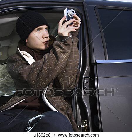 Teenager taking a picture from his car View Large Photo Image Stock Photo - Teenager taking a picture from his car. Fotosearch