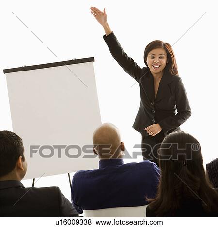 Vietnamese mid-adult woman standing in front of business group gesturing for a presentation. View Large Photo Image Stock Photo - Vietnamese mid-adult woman standing in front of business group gesturing for a presentation.. Fotosearch